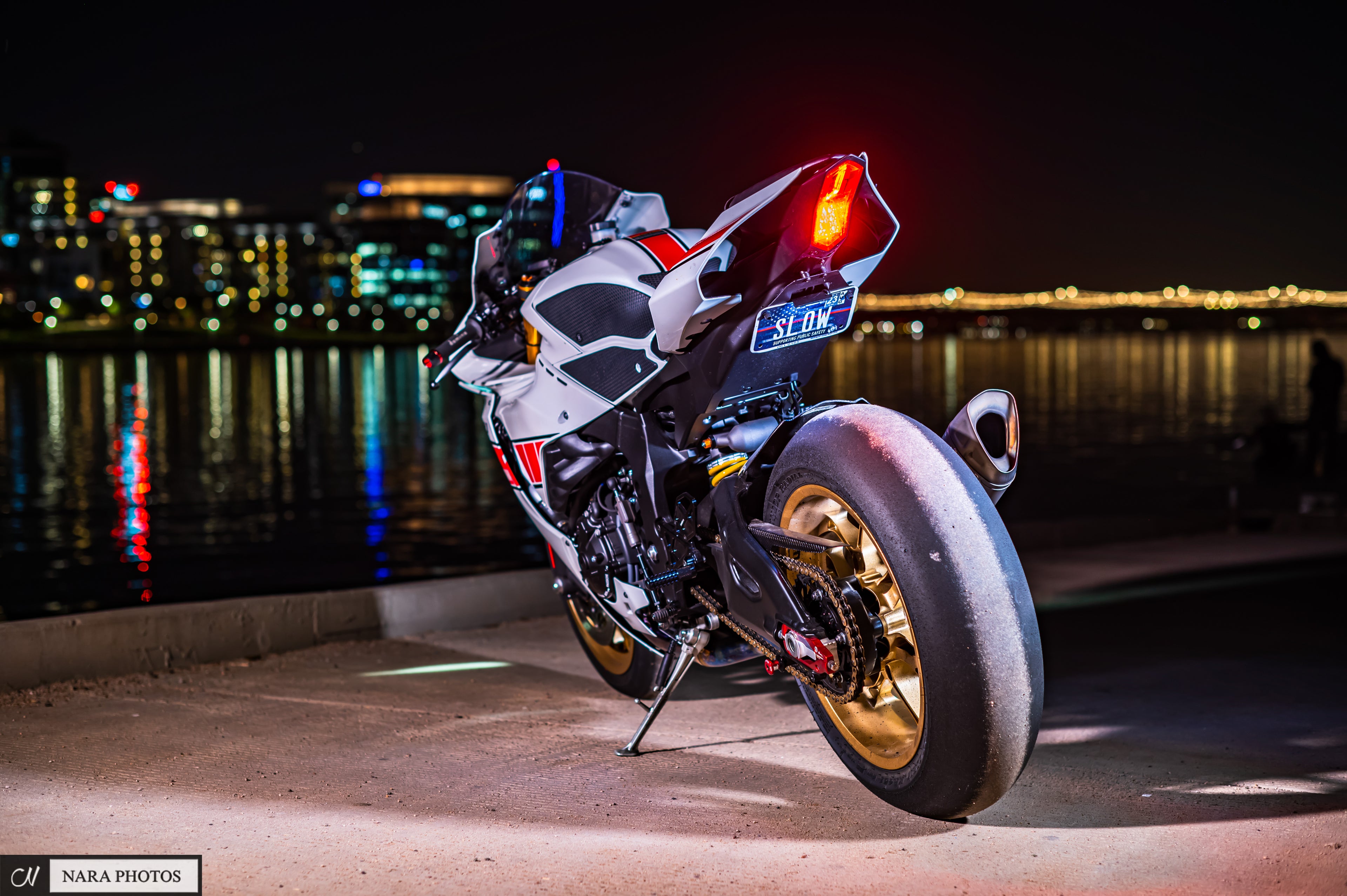 Yamaha R1 rear view at night with a glowing LED tail light by the waterfront